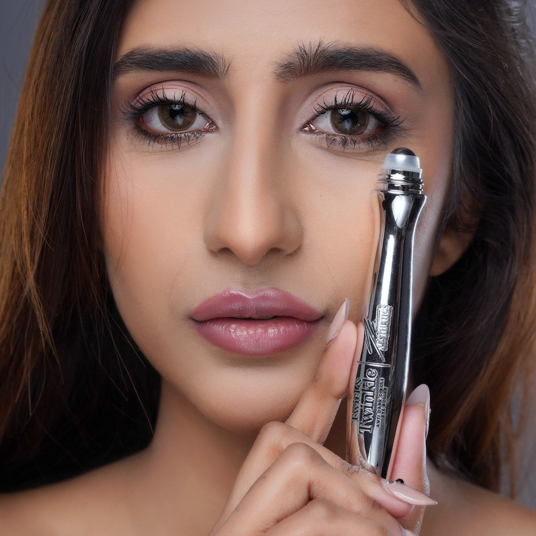 Model holding the Twirl & Twinkle anti dark circle eye roller beside her face